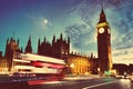 Red bus, Big Ben and Westminster Palace in London, the UK. at night. Moon shining. Vintage Royalty Free Stock Photo