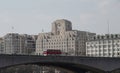 Red bus crossing Waterloo Bridge in front of the former Shell Mex House and Savoy Hotel in London Royalty Free Stock Photo