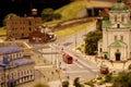 The red bus rides through the streets of the city. Landscape layout with railroad, cars, residential and industrial buildings.