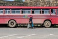 A local lady passing by a red bus stopping around Galle Fort