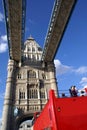 Red bus tour driving across The Tower Bridge in London, England