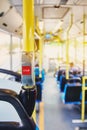 Red button STOP on the bus. Bus with yellow handrails and blue seats. Photo with the sun effect, glare on the lens from the light. Royalty Free Stock Photo