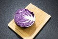 red cabbage ball cut in half with all the leaves on a black gran Royalty Free Stock Photo