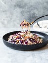 Red cabbage, carrot, cabbage coleslaw salad on black plate on grey background. Copy space Royalty Free Stock Photo