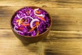 Red cabbage salad in ceramic bowl on wooden table Royalty Free Stock Photo