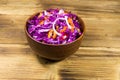 Red cabbage salad in ceramic bowl on wooden table Royalty Free Stock Photo