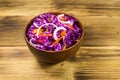 Red cabbage salad in ceramic bowl on wooden table Royalty Free Stock Photo