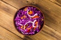 Red cabbage salad in ceramic bowl on wooden table Royalty Free Stock Photo