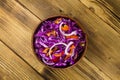 Red cabbage salad in ceramic bowl on wooden table Royalty Free Stock Photo