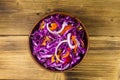 Red cabbage salad in ceramic bowl on wooden table Royalty Free Stock Photo