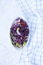 Red cabbage salad. fresh vegetable salad in white ceramic plates and checkered cotton napkin