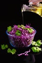 Red cabbage salad with parsley, glass bowl, organic food, olive oil pouring from the bottle Royalty Free Stock Photo