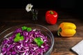 Red cabbage salad with sweet pepper on a wooden table, black background Royalty Free Stock Photo