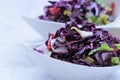 Red cabbage salad.  vegetable salad in white  plates on a light marble background Royalty Free Stock Photo