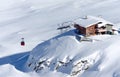 Red cable car and a wooden chalet in winter. Royalty Free Stock Photo