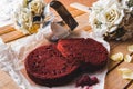 Red cake pies on a parchment and a baking dish in the shape of a heart on a wooden table