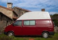 Red Camper Van Parked On The Grass In A Rural Setting