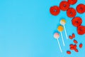 red candies and lollipops on a plain blue background. wallpaper to use text. graphic resource Royalty Free Stock Photo