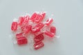 Red candies in transparent wrapper on white background close up top view with copy space Royalty Free Stock Photo