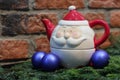 Red candle, blue christmas balls and Santa Claus teapot Royalty Free Stock Photo