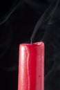Red candle extinguished and with smoke on black background Royalty Free Stock Photo