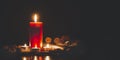 Red Candle with fire against defocused lights in darkness with golden bokeh in the dark Background Royalty Free Stock Photo