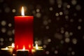 Red Candle with fire against defocused lights in darkness with golden bokeh in the dark Background Royalty Free Stock Photo