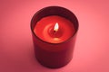 Red candle with flame on pink background. Aromatherapy, relaxation concept Royalty Free Stock Photo