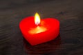 Red candle in the form of a heart on a dark wooden background_ Royalty Free Stock Photo