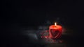 A red candle with a heart image burns on a dark background. Copy space. Royalty Free Stock Photo