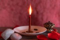 A lit red candle on a pink background, copy paste, Halloween, spiritual beliefs, white magic