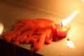 Red candle melting on white mable