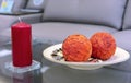 Red candle and a plate with two orange balls Royalty Free Stock Photo