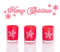 3 red candles, candle holders with crystal snowflakes isolated on reflective white perspex background