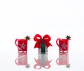 Red candles, candle holders with crystal snowflakes, sugar canes and anise stars and a gift box, isolated on reflective white pers Royalty Free Stock Photo