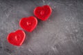 Red candles in the form of hearts on a gray background. The symb Royalty Free Stock Photo