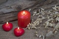 Red candles in heart shape burning on natural burlap background, greeting card, eco idea Royalty Free Stock Photo