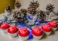 Red candles Heart-shaped among, cones and blue garlands. Valentine& x27;s candles Royalty Free Stock Photo