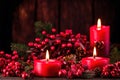 Red candles and red plant fruits for festive holiday celebration