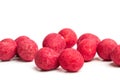 Red candy dipped almonds on a white background