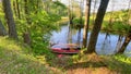 Red canoe in river with paddles surrounded by green Lithuania summer nature. Sports activities leisure in baltics