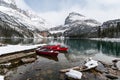 Red canoes parked in snowy valley at wooden pier. Lake O`hara, Yoho national park Royalty Free Stock Photo
