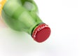 Red cap on the bottle of green glass with a white inscription open lying on white background closeup Royalty Free Stock Photo