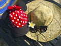 Red cap with white polka dots, straw hat, flowers and sunglasses Royalty Free Stock Photo