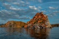 Red cape Shamanka rock in blue Lake Baikal, clouds, sunset, reflection, ripples Royalty Free Stock Photo