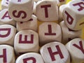 Red Capital Letters on White Wooden Dice Randomly Arranged