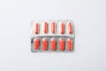 Red capsule pills in blister pack on white background Royalty Free Stock Photo