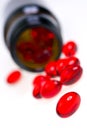 Red capsules and medicine bottle Royalty Free Stock Photo