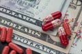 Red capsules or pills on dollar bills Royalty Free Stock Photo