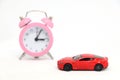 Red car with alarm clock in background. Royalty Free Stock Photo